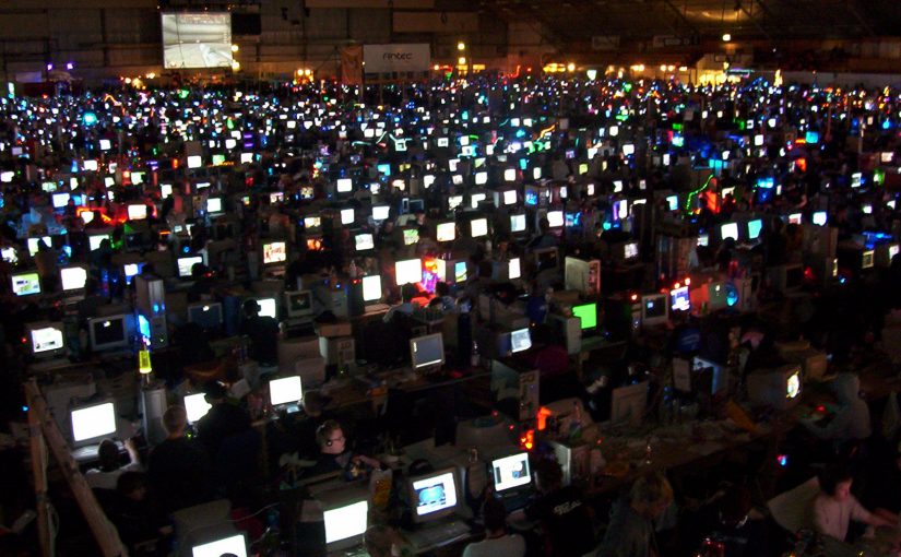 Dunkle Halle mit vielen Computern und Spielern